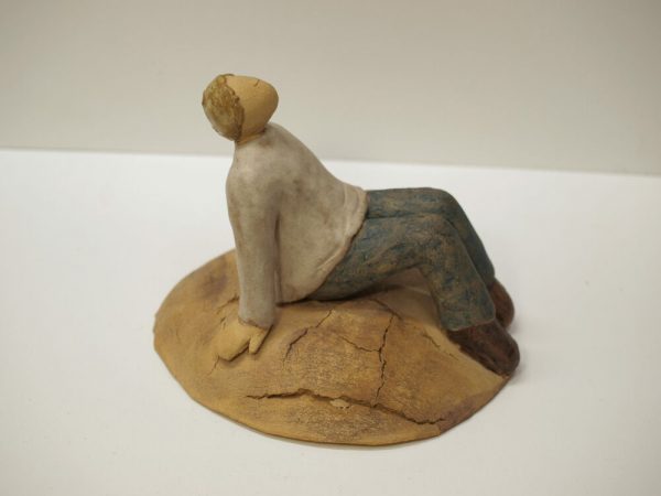 Escultura cerámica de un hombre sentado y relajado