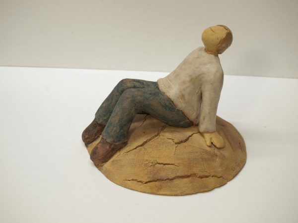 Escultura cerámica de un hombre sentado y relajado