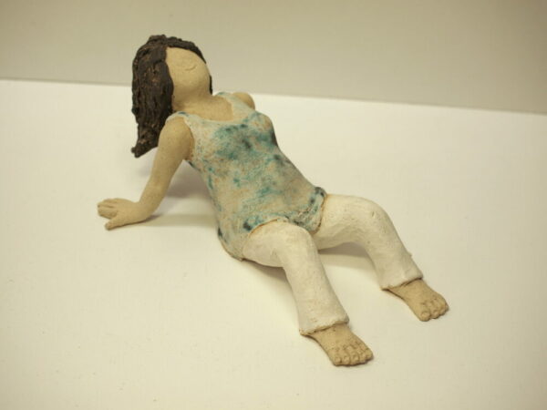 Escultura de cerámica con una mujer embarazada en reposo