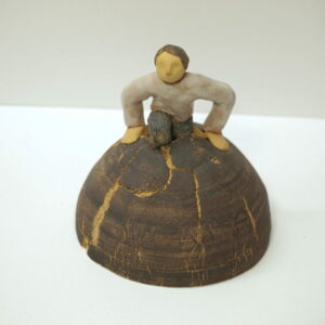 Escultura cerámica que representa a un hombre saliendo de la tierra