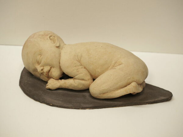 Escultura cerámica de un recién nacido descansando