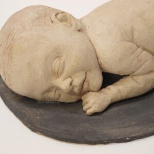 Escultura cerámica de un recién nacido descansando