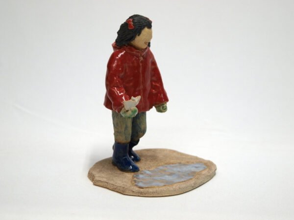 Escultura cerámica de una niña jugando