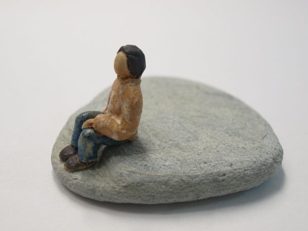 Hombre sentado en piedra